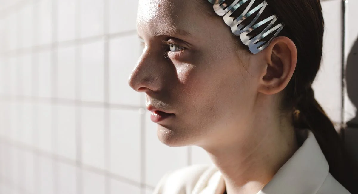 Portrait of a woman with a hair clip, showcasing natural beauty and contemplation.